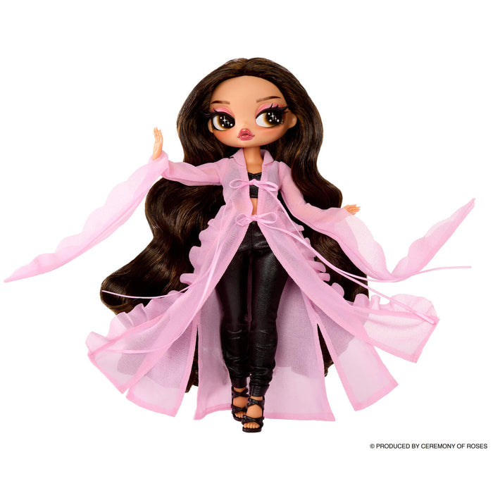Doll with long brown hair with long pink cover up and black pants on a white background