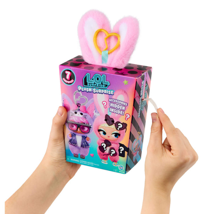 Hands holding a LOL Surprise plush toy packaging with pink ears on a white background
