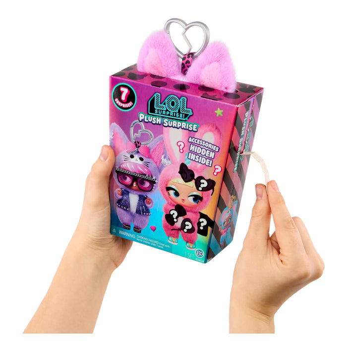 Hands holding a LOL Surprise plush toy packaging with pink ears on a white background