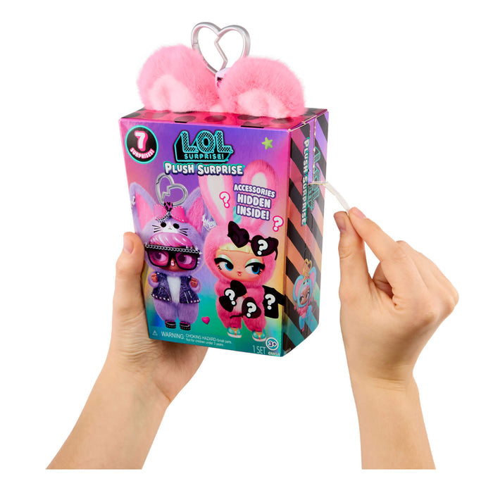 Hands holding a LOL Surprise plush toy packaging with pink ears on a white background