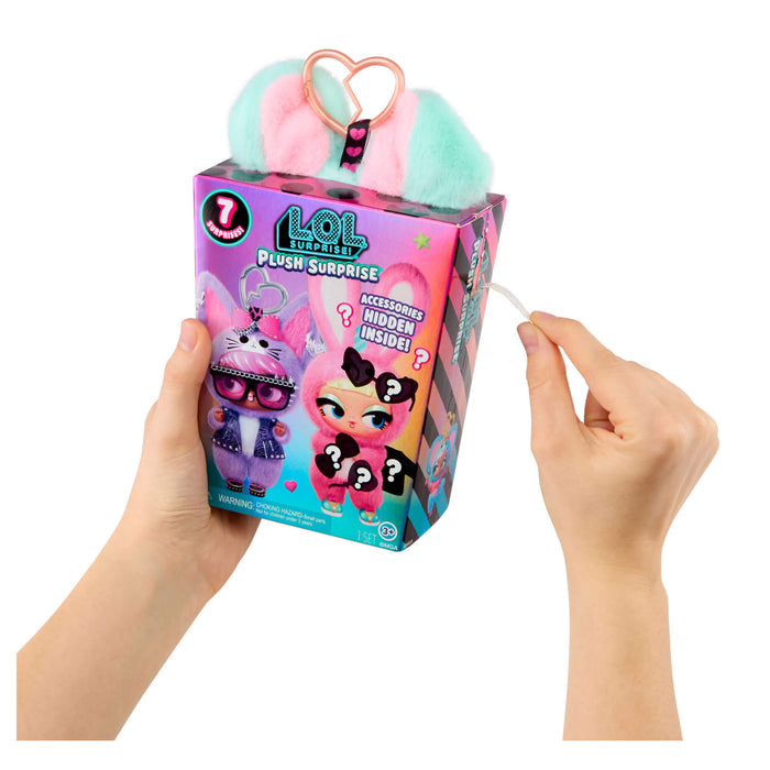 Hands holding a LOL Surprise plush toy packaging with pink  and blue ears on a white background