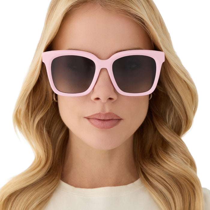 on model - blonde female wearing diff eyewear featuring the meredith square sunglasses with a powder pink frame and grey gradient polarized lenses front view