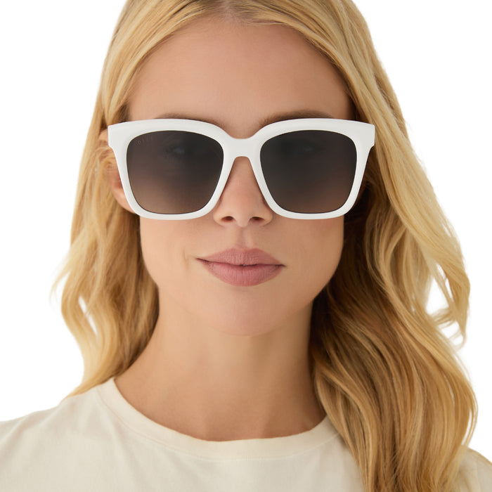 on model - blonde female wearing diff eyewear featuring the meredith square oversized sunglasses with a white snowbound acetate frame and grey gradient polarized lenses front view