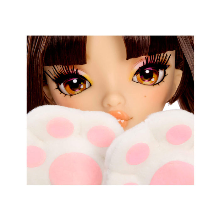 Close-up of a doll's face with brown hair and large brown eyes, partially covered by white plush paw-shaped props with pink polka dots.
