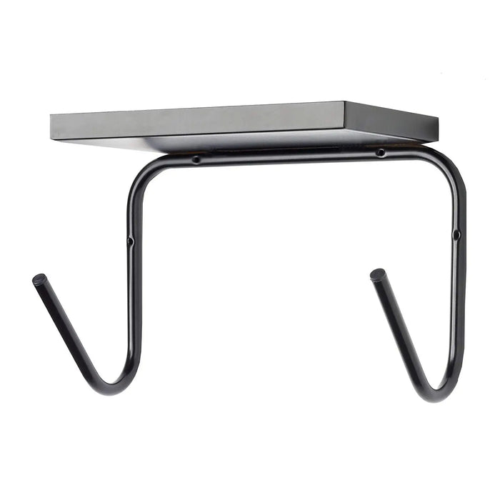 A black metal shelf is mounted on a curved bracket with two hook-like extensions below. It is designed for holding items while providing hanging space beneath in a minimalist setting.