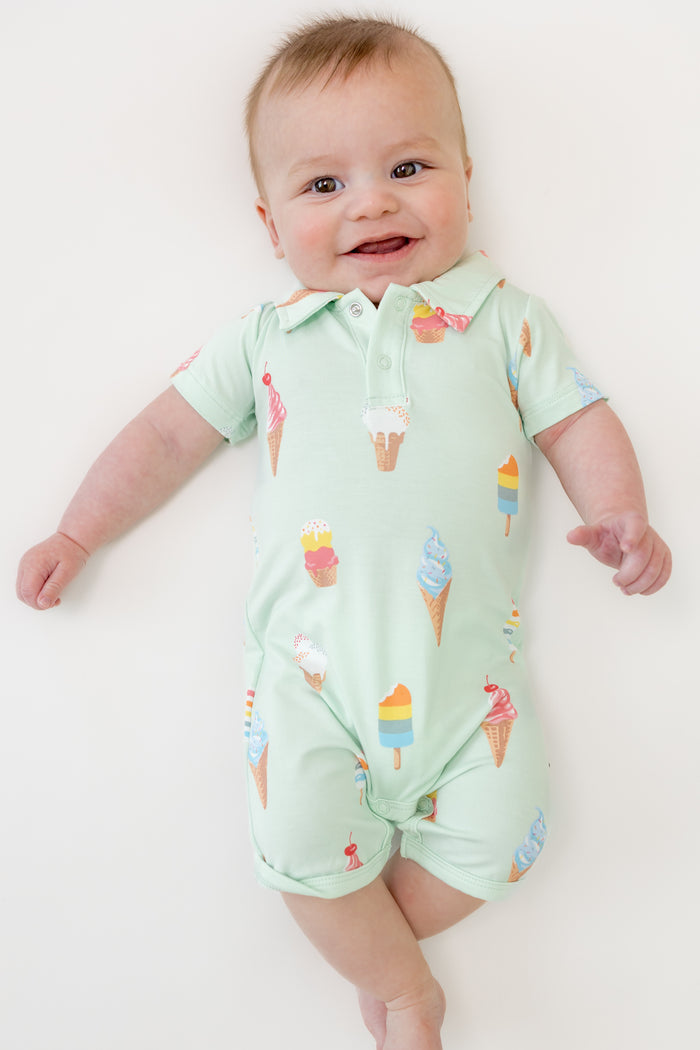 Baby smiling in Mint Ice Cream Polo Shortall on a beige background
