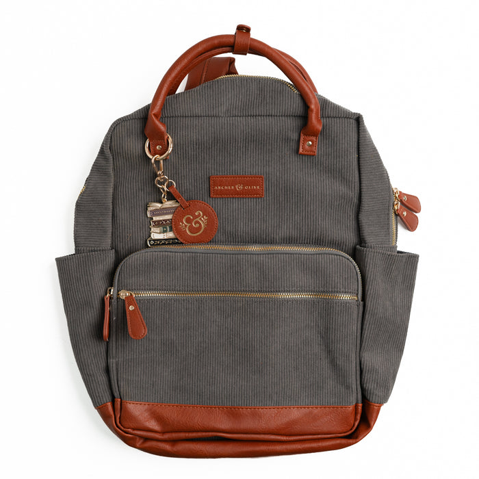 Charcoal gray ribbed corduroy backpack with brown vegan leather trim and book-stack keychain