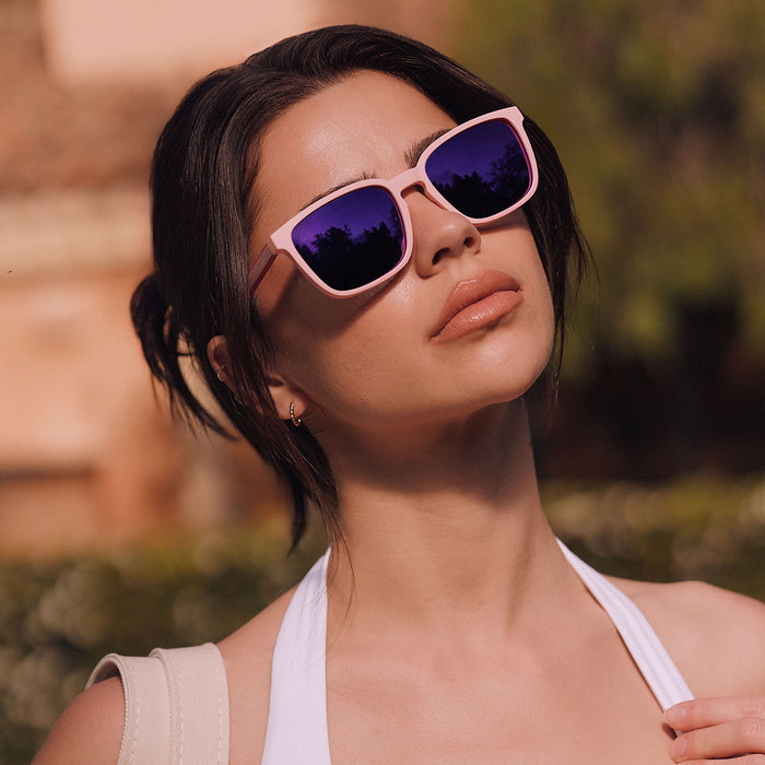 lifestyle - female at a country club wearing diff sport featuring the rush square sunglasses with a matte baby pink frame and pink rush mirror polarized lenses