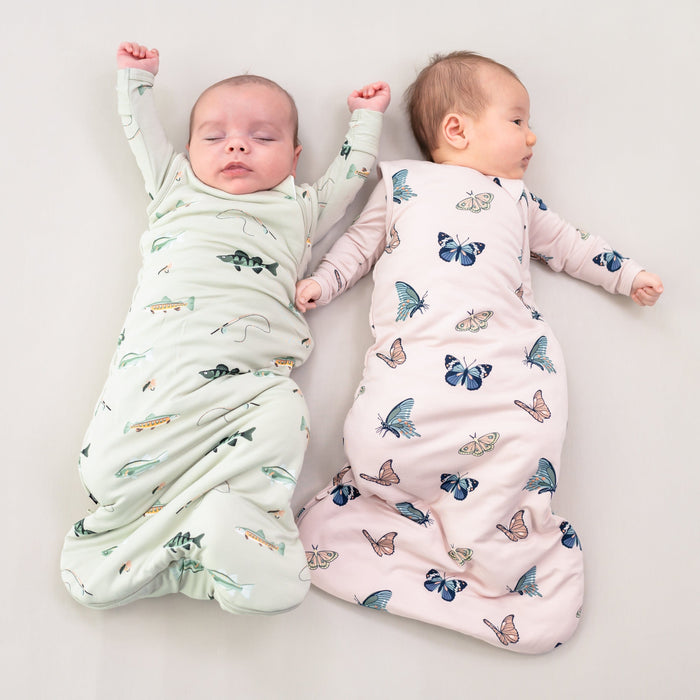 Babies wearing Kyte Baby sleep bags TOG 1.0 in Fishing and Blush Butterfly prints