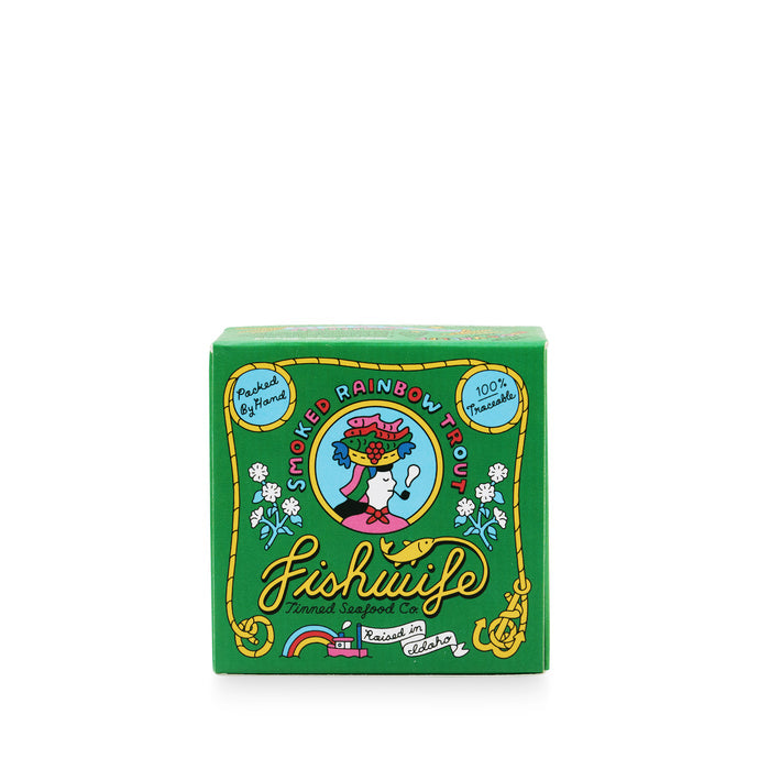 A green box of Fishwife Tinned Fish Co. smoked rainbow trout that features an illustration of a woman carrying fish on her head.