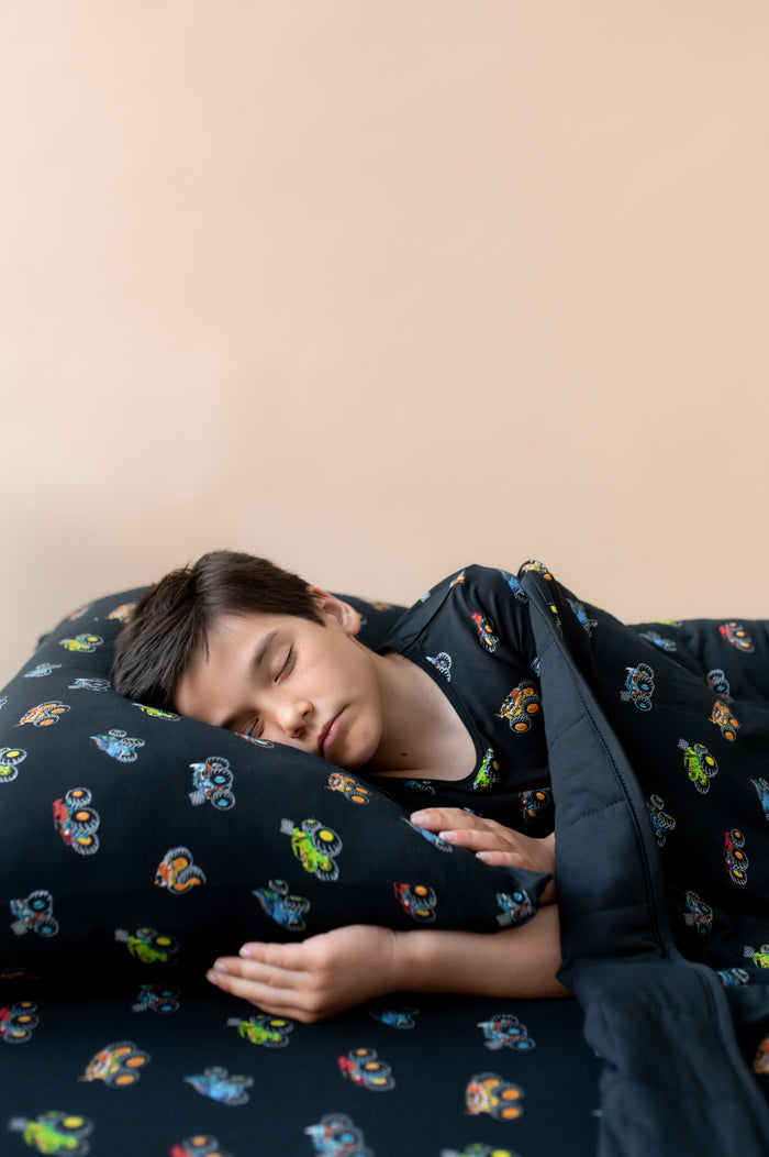 Boy sleeping on Black Standard Pillowcase and sheet in Monster Truck print covered under similar print  Blanket