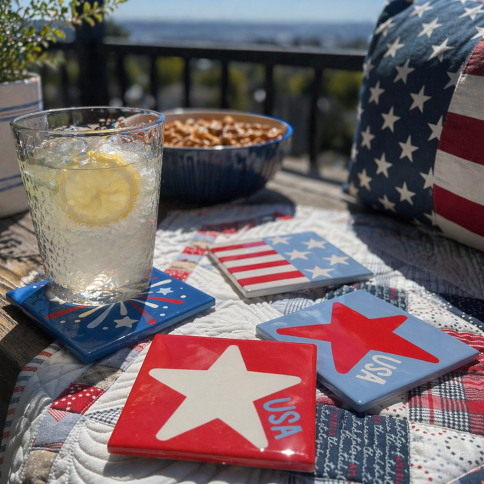 Outdoor setting with a glass of lemonade, bowl of snacks, and patriotic coasters on a table.