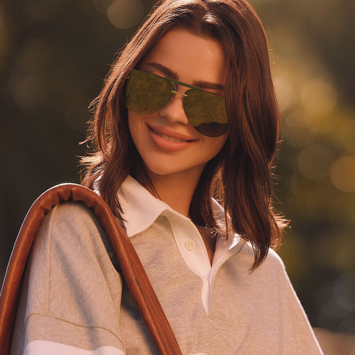 lifestyle - female wearing diff eyewear featuring the tahoe aviator sunglasses with a gold metal and green accent frame with a aloe green gradient and light gold flash polarized sunglasses front view