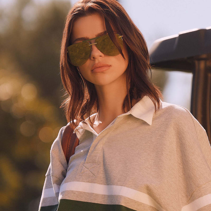 lifestyle - female wearing diff eyewear featuring the tahoe aviator sunglasses with a gold metal and green accent frame with a aloe green gradient and light gold flash polarized sunglasses front view