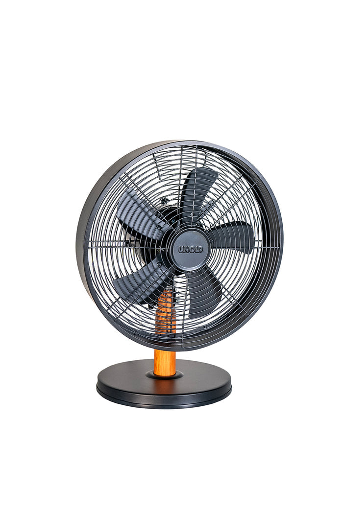 Der Unold Tischventilator Black Steel ist ein moderner schwarzer elektrischer Tischventilator mit rundem Sockel, Holzakzent am Ständer, Schutzgittern und fünf Flügeln, die isoliert auf weißem Hintergrund dargestellt sind.
