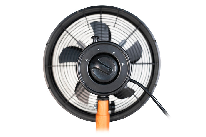 Nahaufnahme des Unold Tischventilators Black Steel, eines schwarzen elektrischen Ventilators mit drei Geschwindigkeitsstufen, rundem Gitter und zentralem Geschwindigkeitsregler auf einem eleganten Holzständer, von vorne betrachtet.