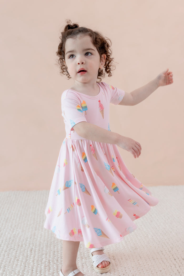Child wearing Twirl Dress in Sakura Ice Cream print on a beige background
