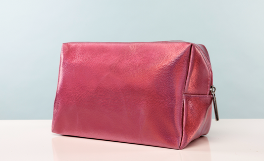 Red leather toiletry bag on a light gray background